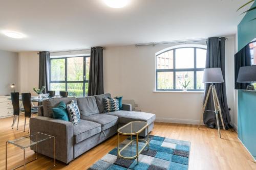 a living room with a couch and a table at Cotels The Millhouse Corporate Apartments - PRIVATE APARTMENT BUILDINGS - GATED ENTRANCE - PARKING - WORK DESK in Derby