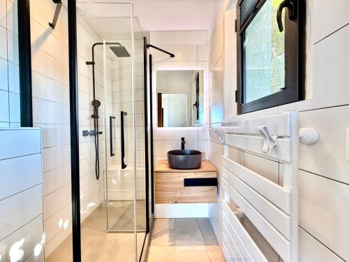 une salle de bain avec une douche en verre et un lavabo dans l'établissement Villa Altezza - vue mer 270°, à Porto-Vecchio
