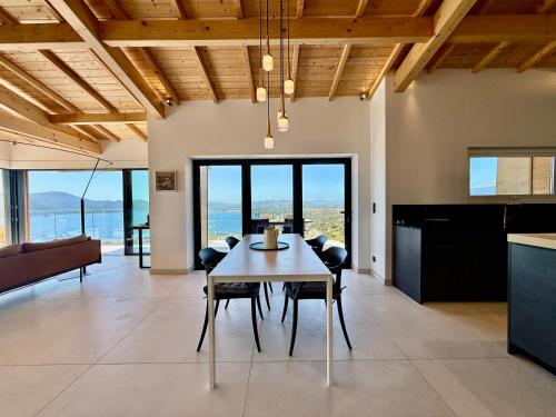 une cuisine et une salle à manger avec une table et des chaises dans l'établissement Villa Altezza - vue mer 270°, à Porto-Vecchio