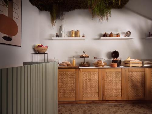 a kitchen with wooden cabinets and a white wall at Shellona Rooms & Apartments in Laganas