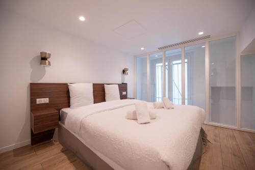 une chambre avec un grand lit blanc avec une fenêtre dans l'établissement CIA - Duplex in Heart of Paris, à Paris