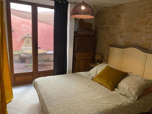 une chambre avec un lit et une grande fenêtre dans l'établissement appartement de charme, à Lançon-Provence