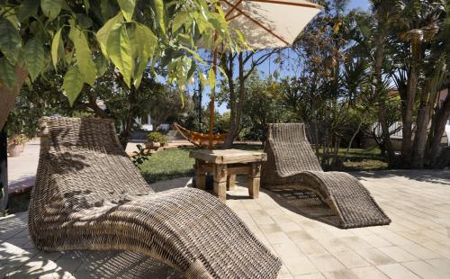 two wicker chairs and a table on a patio at Villa Sandoval in Palermo