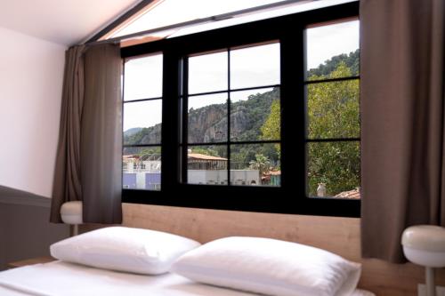 ein Bett mit zwei Kissen vor einem Fenster in der Unterkunft Dalyan Lorend Inn in Dalyan