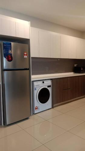a kitchen with a stainless steel refrigerator and a dishwasher at Suasana Suites Johor Bahru City Centre in Johor Bahru