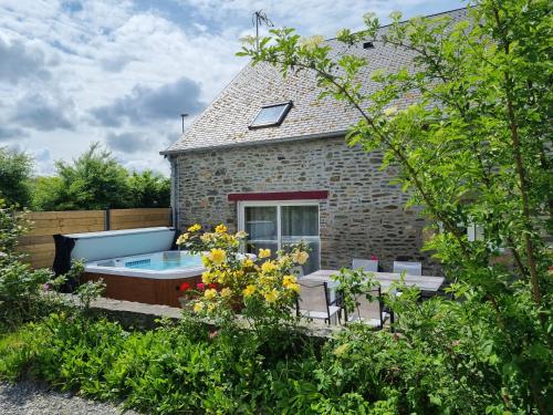 un jardin avec un bain à remous en face d'une maison dans l'établissement Au Mont De La Rive #Jaccuzi et Mont-Saint-Michel #, à Pontorson