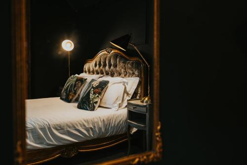 a reflection of a bed in a mirror at Le Petit Chateau & William de Percy in Otterburn