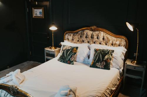a bedroom with a bed with white sheets and pillows at Le Petit Chateau & William de Percy in Otterburn