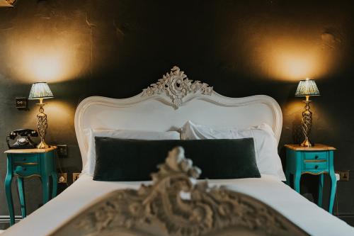 a bedroom with a white bed with two night stands at Le Petit Chateau & William de Percy in Otterburn