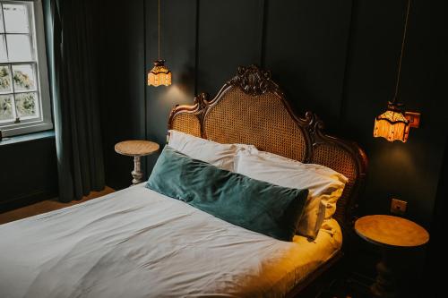 a bed with a wooden headboard with a pillow on it at Le Petit Chateau & William de Percy in Otterburn