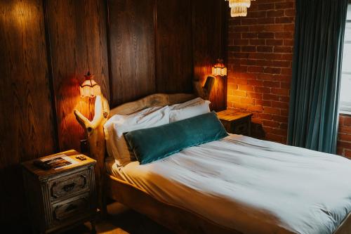a bedroom with a bed with a blue pillow on it at Le Petit Chateau & William de Percy in Otterburn