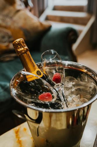 a glass bowl with wine glasses and a bottle of champagne at Le Petit Chateau & William de Percy in Otterburn