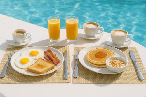 a breakfast table with eggs bacon and toast and coffee at Blue Summer Luxury Suites in Kourouta