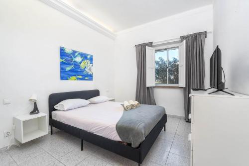 a bedroom with a bed and a flat screen tv at Blife Riamya private rooms in Faro