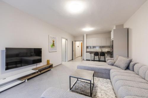 a living room with a couch and a large tv at Seaview Apartment in the Center of Saranda in Sarandë