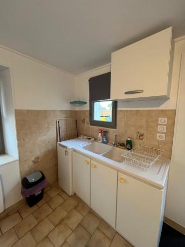 une petite cuisine avec un évier et une fenêtre dans l'établissement La petite maison, à Souday