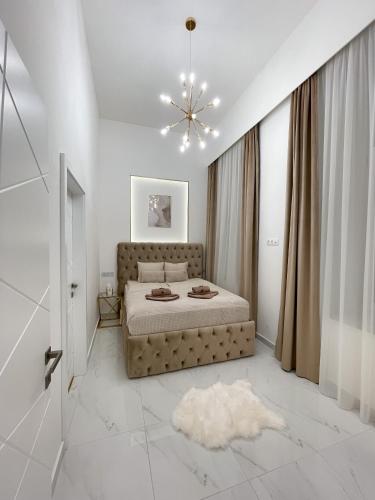 ein Schlafzimmer mit einem Bett und einem Kronleuchter in der Unterkunft St Stephen Luxury Spa Residence in Budapest