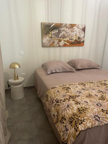a bedroom with two beds and a painting on the wall at Les oliviers in Aléria