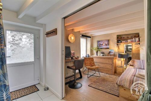 - une chambre avec un bureau, un lit et une chaise dans l'établissement La petite maison de dom, à Pleslin-Trigavou