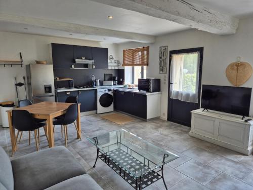 un salon avec une table et une cuisine dans l'établissement L'Abaca 25, à Sainte-Geneviève-lès-Gasny