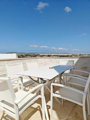 a table and chairs on a balcony with the beach at BluSky in Safi