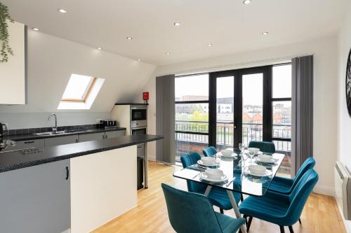 a kitchen and dining room with a table and chairs at Cotels The Millhouse Corporate Apartments - PRIVATE APARTMENT BUILDINGS - GATED ENTRANCE - PARKING - WORK DESK in Derby