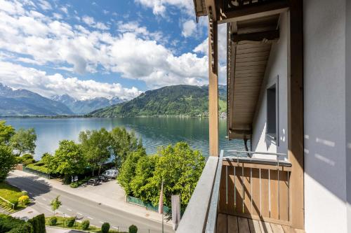 a balcony with a view of a lake and mountains at Seehotel Bellevue by keyone in Zell am See