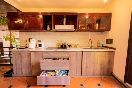 a kitchen with wooden cabinets and a sink at Vườn Tùng RiverSide retreat & Villa - KDT ECOPARK in Kim Quan