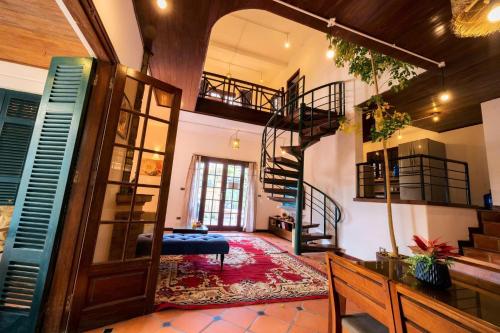 a living room with a spiral staircase in a house at Vườn Tùng RiverSide retreat & Villa - KDT ECOPARK in Kim Quan