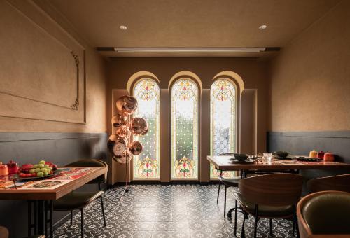a dining room with two tables and a window at SIXI CANGSHAN MOUNTAINS GOLDEN SUNRISE MIRROR OF THE SKY SOUND SLEEP HOTEL DALI ANCIENT CITy in Dali