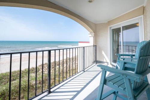 a balcony with two blue chairs and the beach at Villa Capriani 218B Oceanfront with Pool at North Topsail Beach in Chadwick Acres