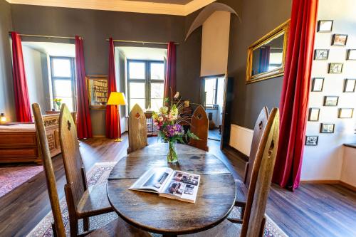 a dining room table with a vase of flowers on it at Schloss Arenfels in Bad Hönningen