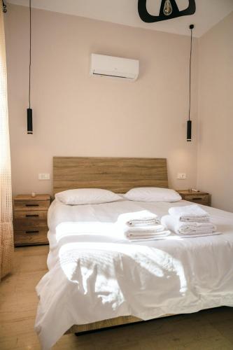 a bedroom with a white bed with towels on it at Euphoria Loft in Karfas