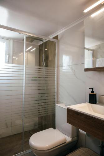 a white bathroom with a toilet and a sink at Euphoria Loft in Karfas