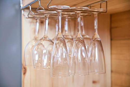 a group of wine glasses hanging from a rack at LEVATA in Nasu