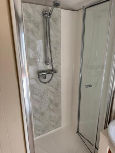 a shower with a glass door in a bathroom at Whitwell and Reepham Station - Tom in Norwich