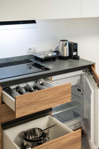 a kitchen with an open drawer with pots and pans at Monolocale Margherita - Cascina Da Rosa in Capiago Intimiano