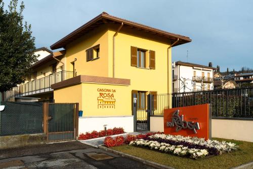 a yellow house with a sign in front of it at Monolocale Margherita - Cascina Da Rosa in Capiago Intimiano