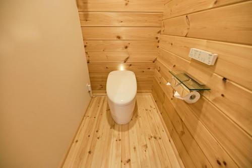 a small bathroom with a toilet in a wooden wall at LEVATA in Nasu