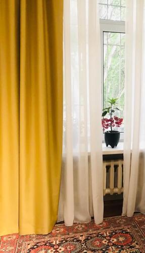 a yellow curtain in a room with a window at Уютный уголок рядом с ЦУМом и ГУМом 1 in Bishkek