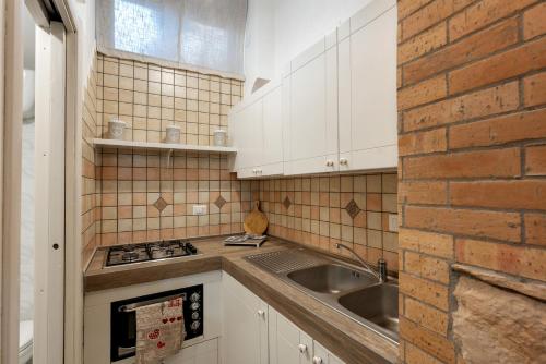 eine Küche mit Spüle und Ziegelwand in der Unterkunft La Cantina Di Alba e Tramonto in Pimonte