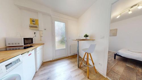 une cuisine aux murs blancs et un comptoir avec un four micro-ondes dans l'établissement Evasion de Oiseau - Lesueur, au Havre