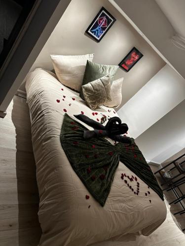 un lit avec une couette blanche avec une paire de ciseaux dessus dans l'établissement Valentine's secret Room spa, à Margny-lès-Compiègne