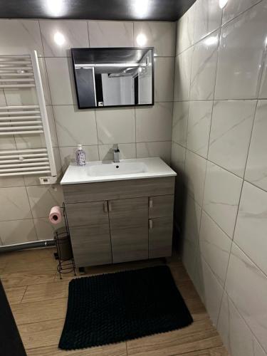 une salle de bain avec un lavabo et un miroir dans l'établissement Valentine's secret Room spa, à Margny-lès-Compiègne