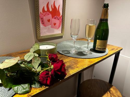 - une table avec une bouteille de champagne et 2 verres dans l'établissement Valentine's secret Room spa, à Margny-lès-Compiègne