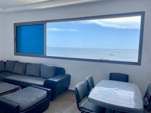 a living room with a couch and a large window at Luxury beach apartment in Kerkennah in Ouled Kacem
