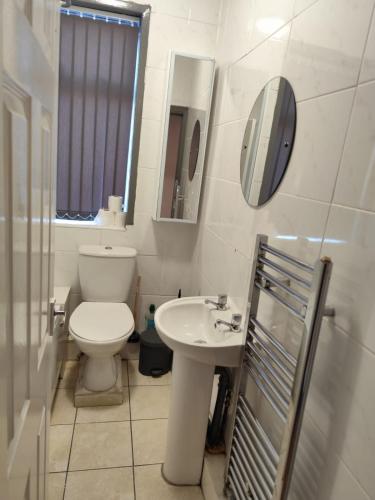 a bathroom with a toilet and a sink and a mirror at Double-Bedroom in the Heart of Harpurhey Manchester A1 Perfect for Short Stays in Manchester