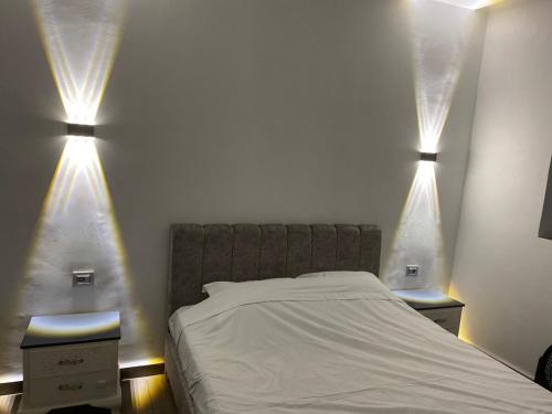 a bedroom with a bed with two lights on it at Luxury beach apartment in Kerkennah in Ouled Kacem