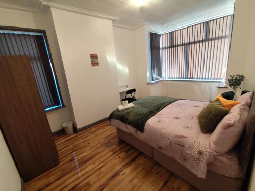 a bedroom with a bed and a wooden floor at Double-Bedroom in the Heart of Harpurhey Manchester A1 Perfect for Short Stays in Manchester
