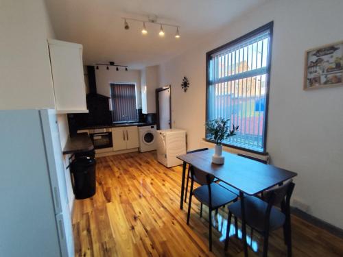 a living room with a dining room table and a kitchen at Double-Bedroom in the Heart of Harpurhey Manchester A1 Perfect for Short Stays in Manchester